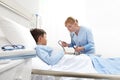 Child lying in bed in hospital room and nurse measuring his pressure with sphygmomanometer and stethoscope Royalty Free Stock Photo